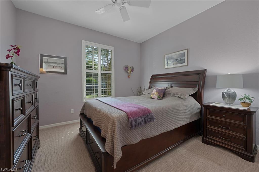 Carpeted bedroom with ceiling fan and baseboards