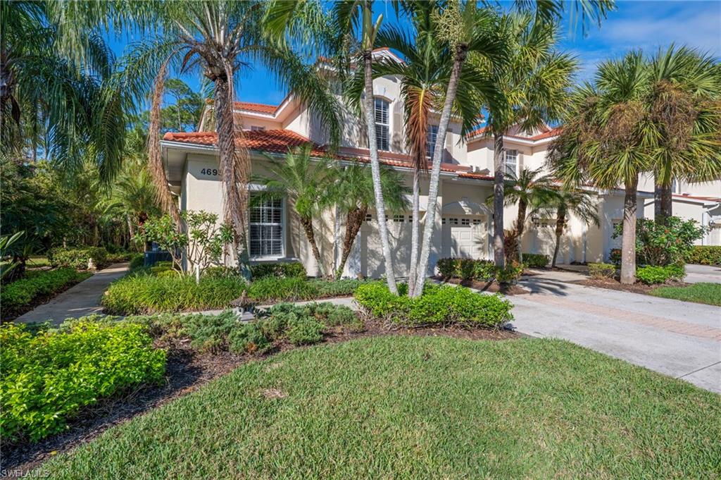 Mediterranean / spanish home with driveway, stucco siding, a front lawn, a tiled roof, and an attached garage