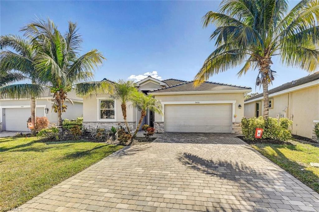 Single story home with stone siding, decorative driveway, and stucco siding