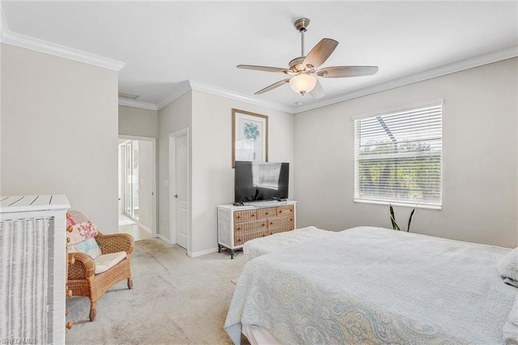 Carpeted bedroom with crown molding and ceiling fan