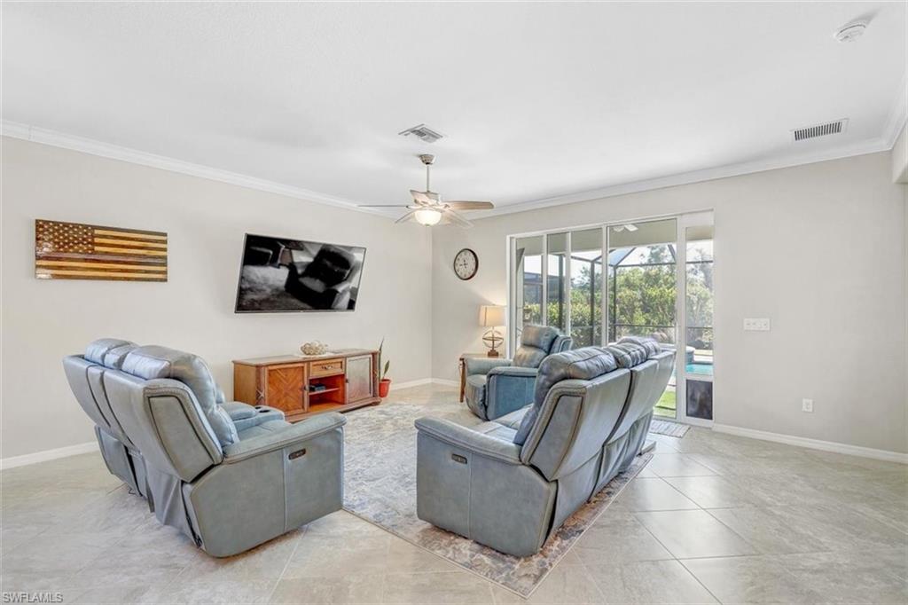 Living area featuring crown molding, a ceiling fan, and light tile patterned floors