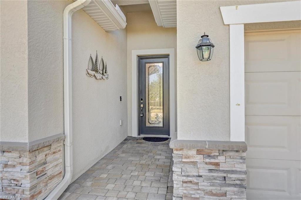 Doorway to property featuring stucco siding