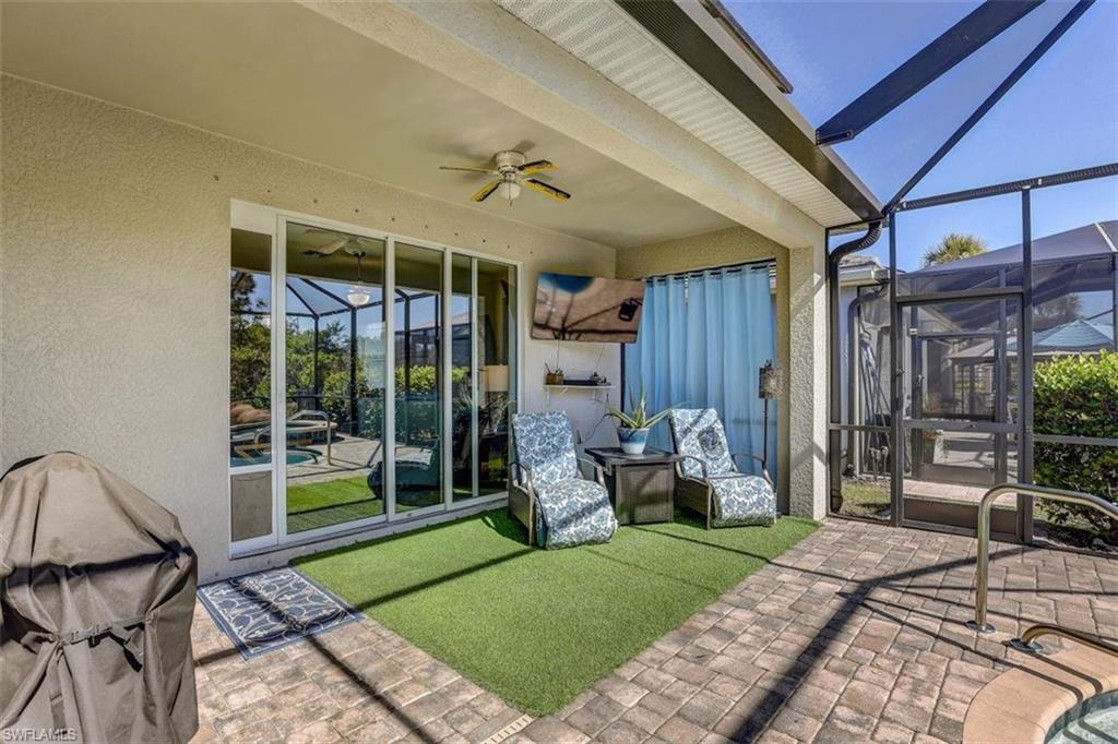 View of patio featuring a lanai, a sunroom, and a ceiling fan