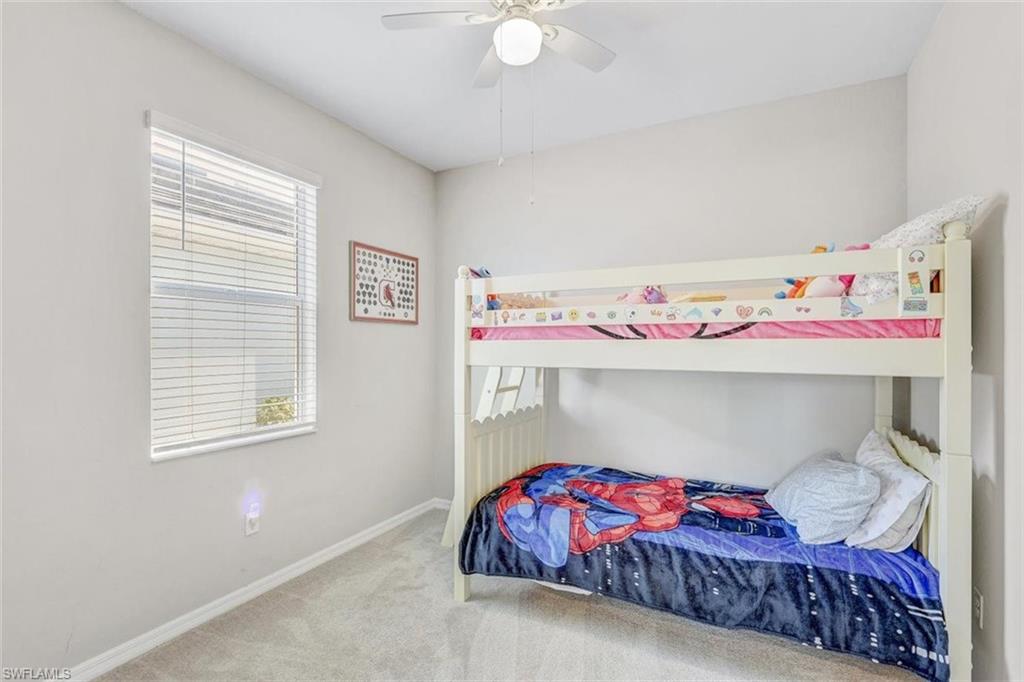 Carpeted bedroom with baseboards and a ceiling fan