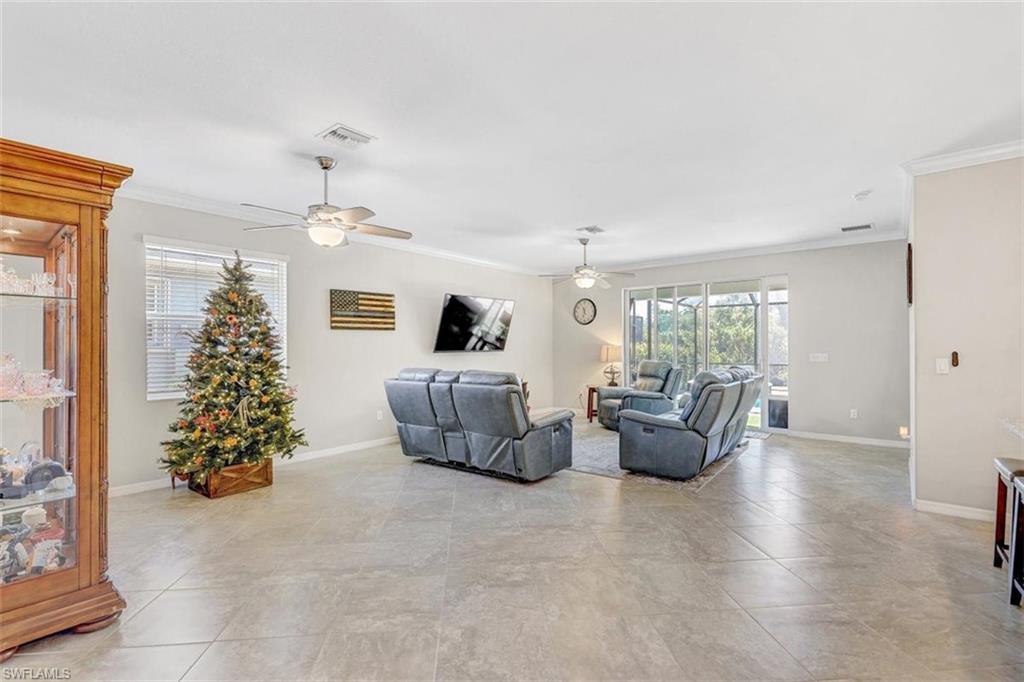 Living area featuring crown molding and light tile patterned flooring
