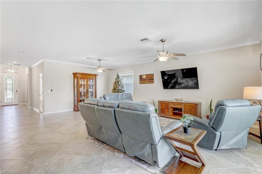 Living room with ornamental molding and ceiling fan