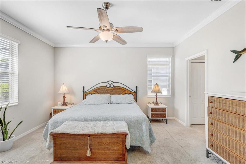 Bedroom with crown molding, light carpet, and a ceiling fan