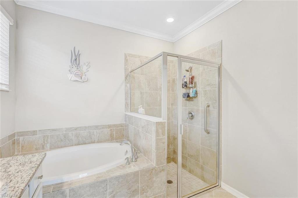 Full bath with a garden tub, crown molding, vanity, a shower stall, and tile patterned floors