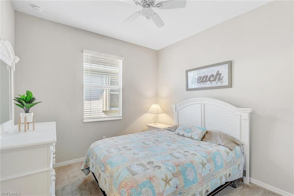Carpeted bedroom featuring a ceiling fan and baseboards