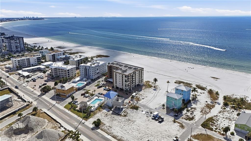 Aerial view of apartment complex / building and expansive coastline- virtually enhanced