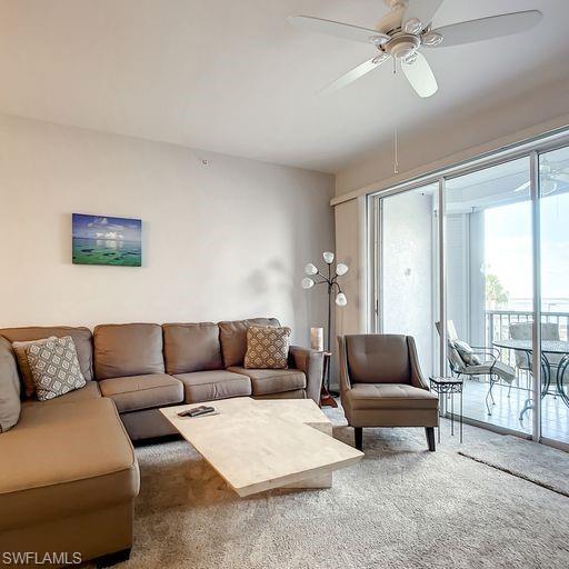 Living area featuring a ceiling fan and carpet