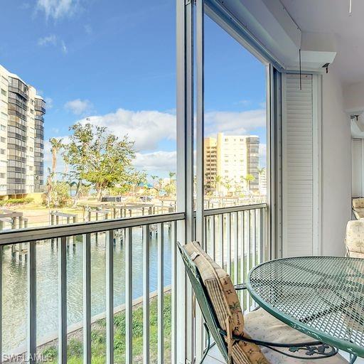 Balcony with a sunroom, a water view, and a city view