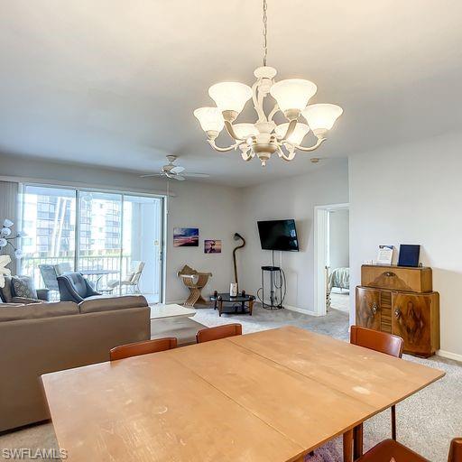 Dining room with light colored carpet, ceiling fan, and a chandelier