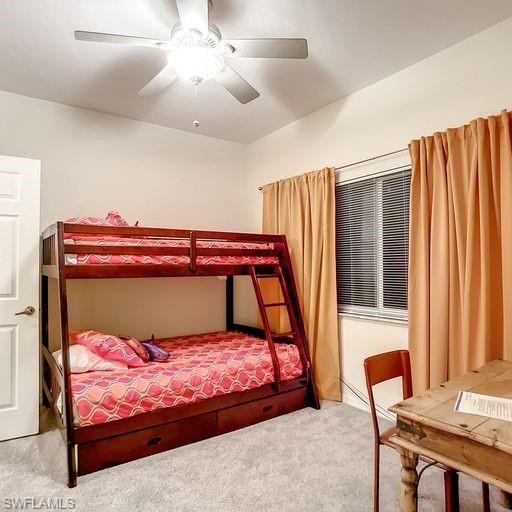 Carpeted bedroom with a ceiling fan