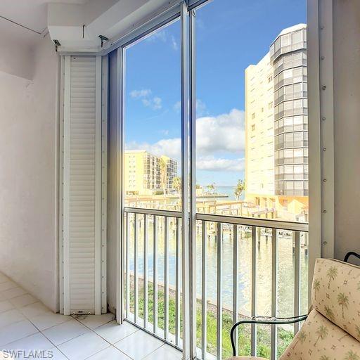 Balcony featuring a water view and a sunroom
