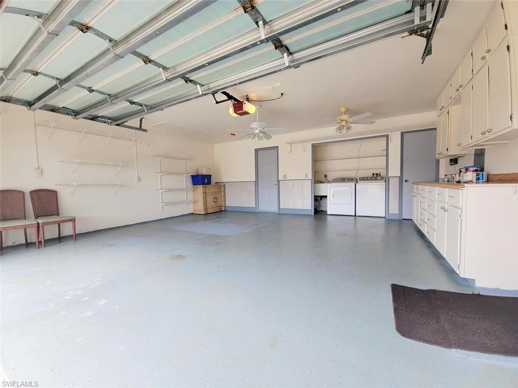 Garage featuring washer and dryer and a garage door opener