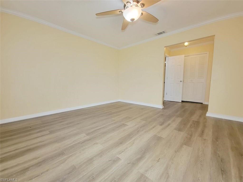 Unfurnished room with crown molding, light wood finished floors, and ceiling fan