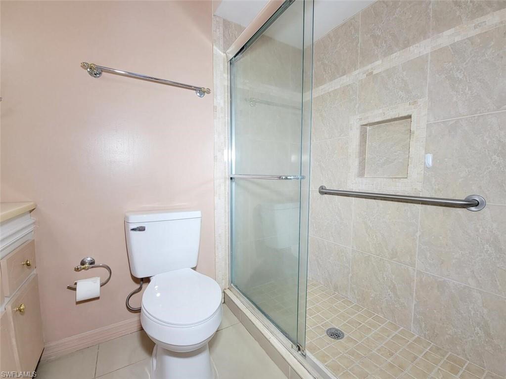Bathroom with a shower stall, vanity, and tile patterned floors