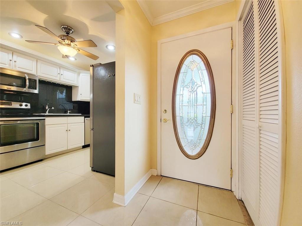 Entryway featuring light tile patterned floors, ornamental molding, ceiling fan, and recessed lighting