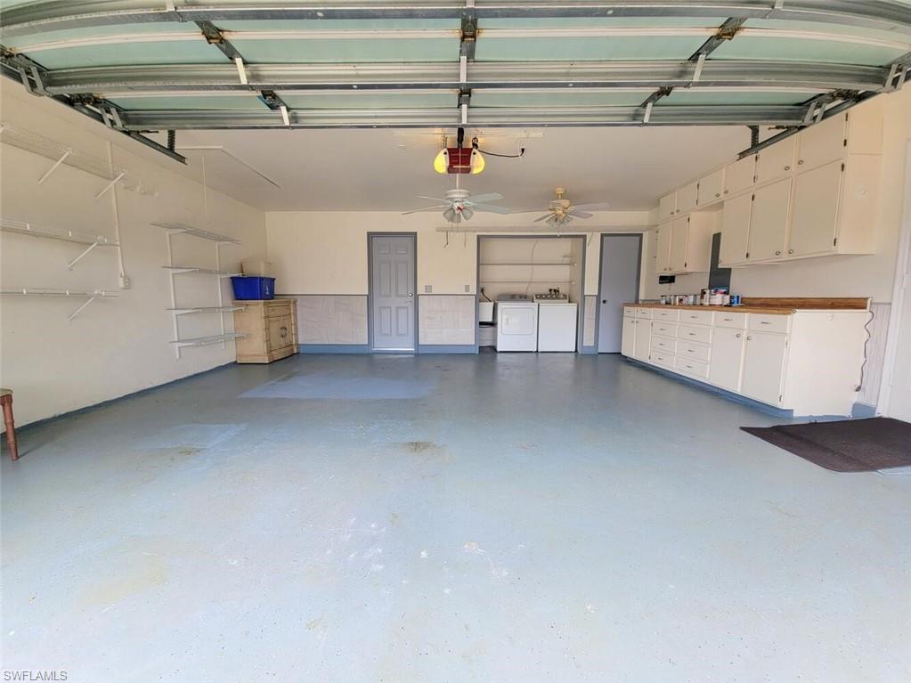 Garage featuring washer and clothes dryer and a garage door opener