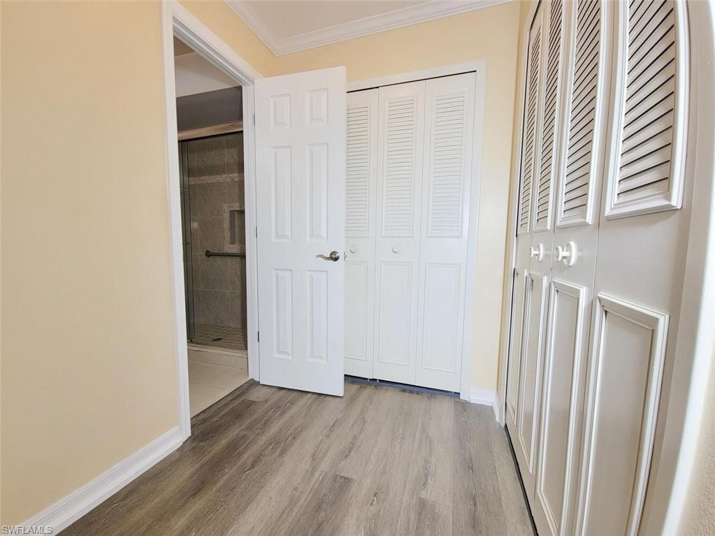 Unfurnished bedroom with crown molding, wood finished floors, and a closet