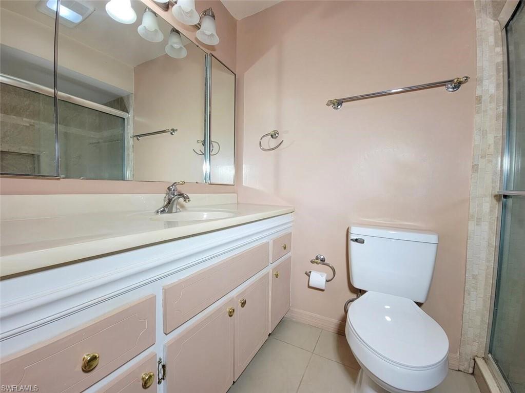 Full bath with a shower stall, vanity, and light tile patterned flooring