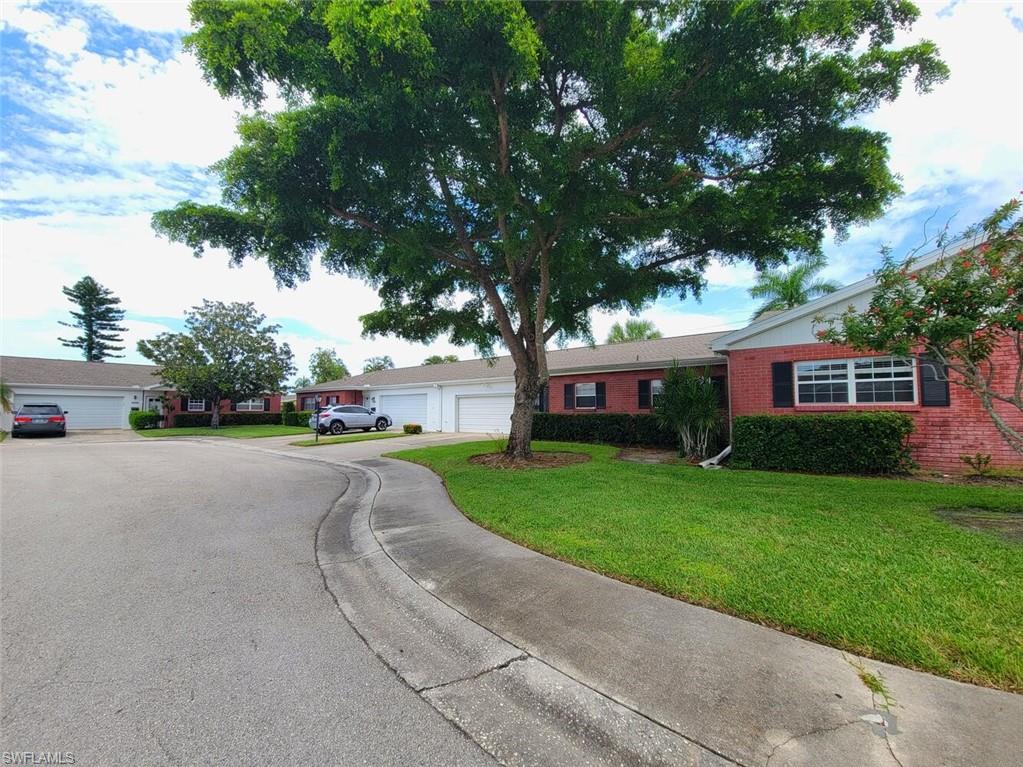 Ranch-style house featuring a front lawn, brick siding, and driveway