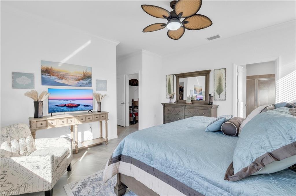 Bedroom with crown molding, ceiling fan, and tile patterned floors