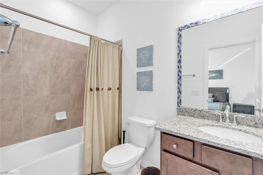 Bathroom with shower / bath combo, vanity, and ensuite bath