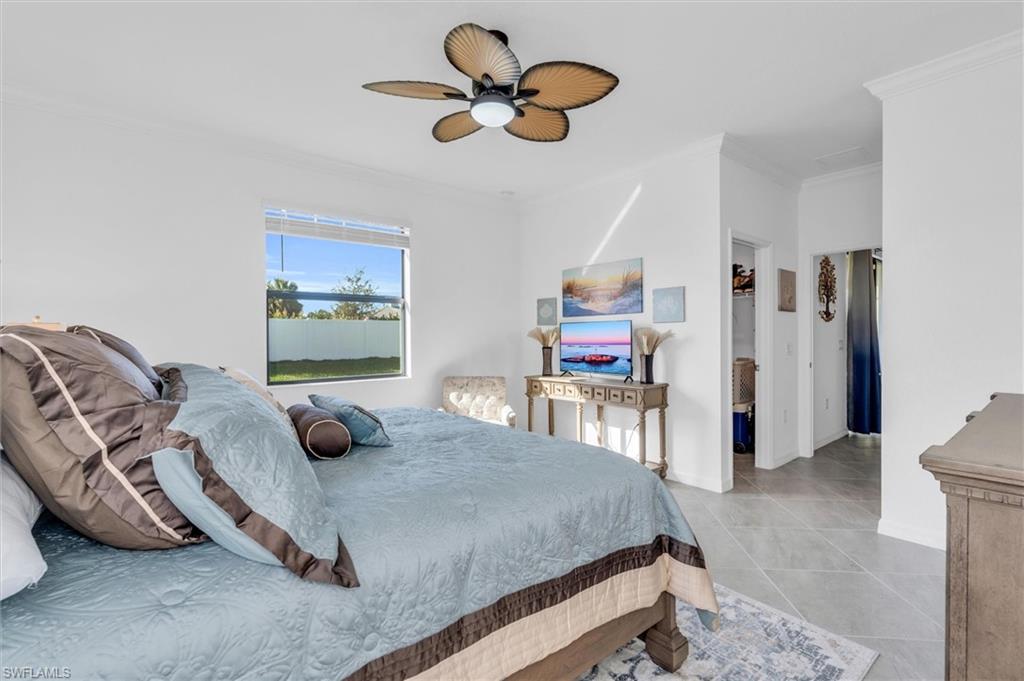 Bedroom featuring crown molding, a ceiling fan, and light tile patterned flooring