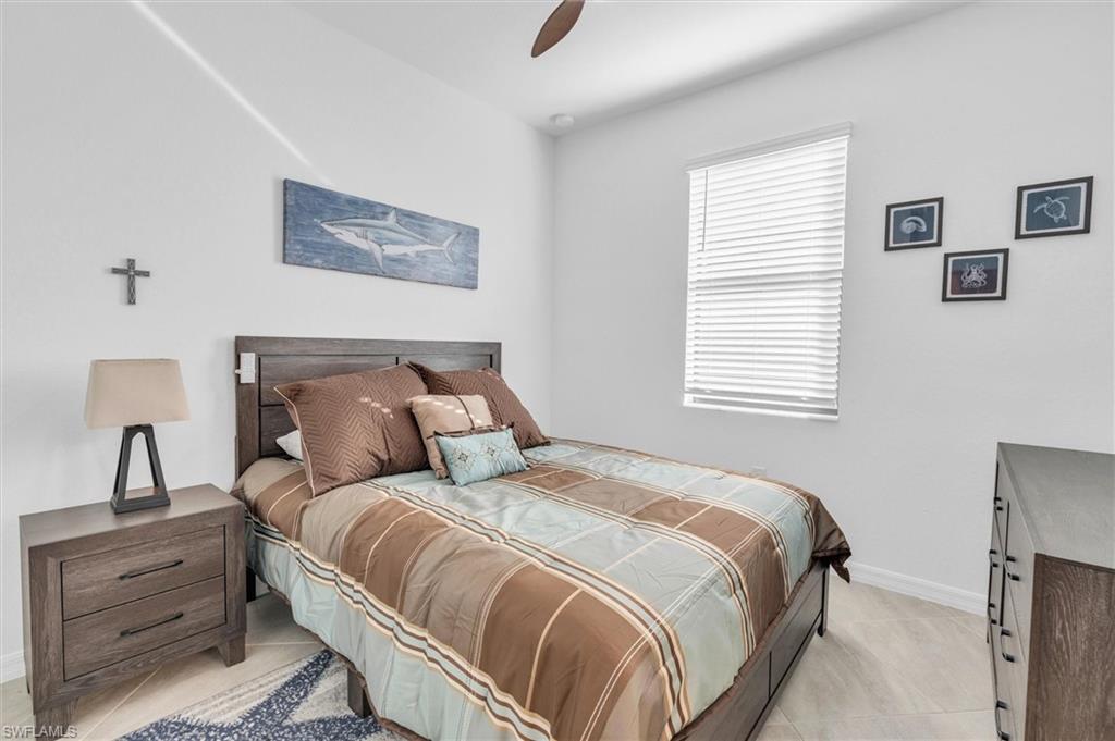 Bedroom with light tile patterned floors and a ceiling fan