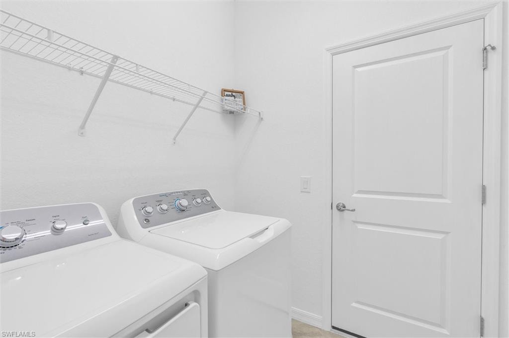 Laundry room with washer and dryer and baseboards