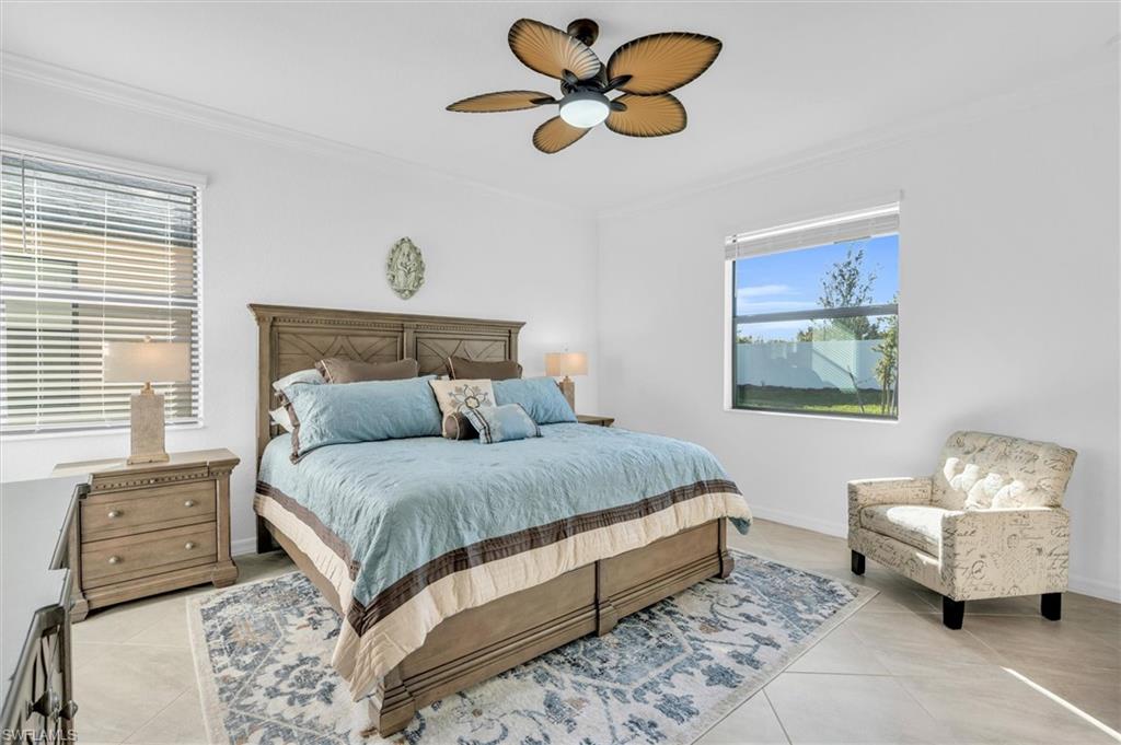 Bedroom featuring crown molding, a ceiling fan, and light tile patterned floors