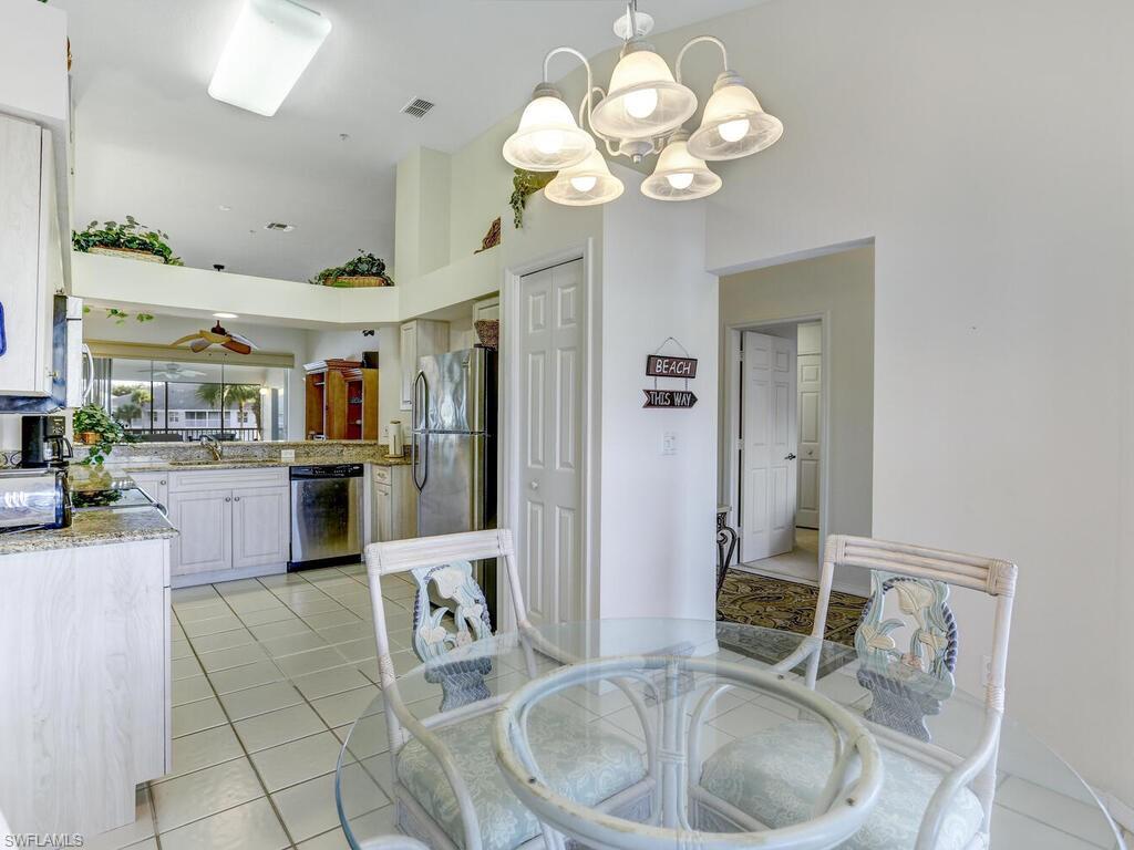 Dining room with light tile patterned floors and a towering ceiling