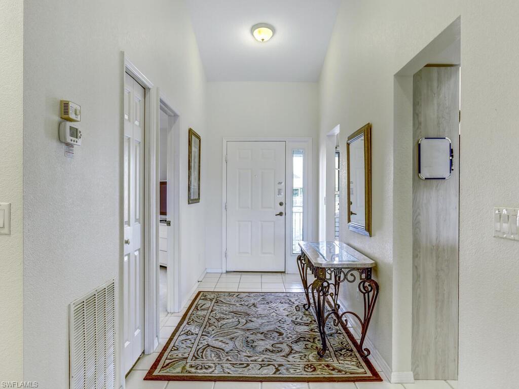 Entrance foyer featuring a textured wall and light tile patterned floors