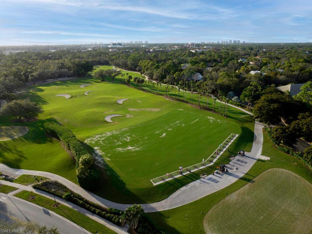 Aerial view of property's location with a tree filled landscape and a golf course