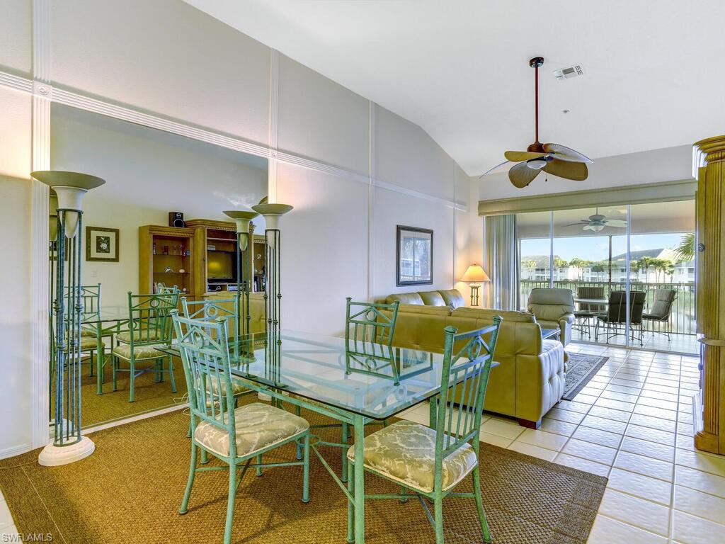 Dining room with vaulted ceiling, ceiling fan, and tile patterned floors