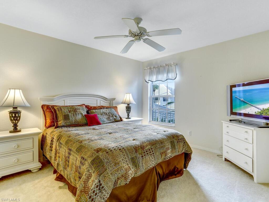 Bedroom with light carpet and a ceiling fan