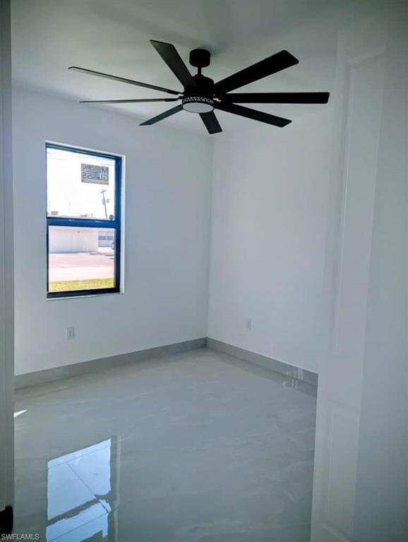 Spare room with finished concrete floors and ceiling fan