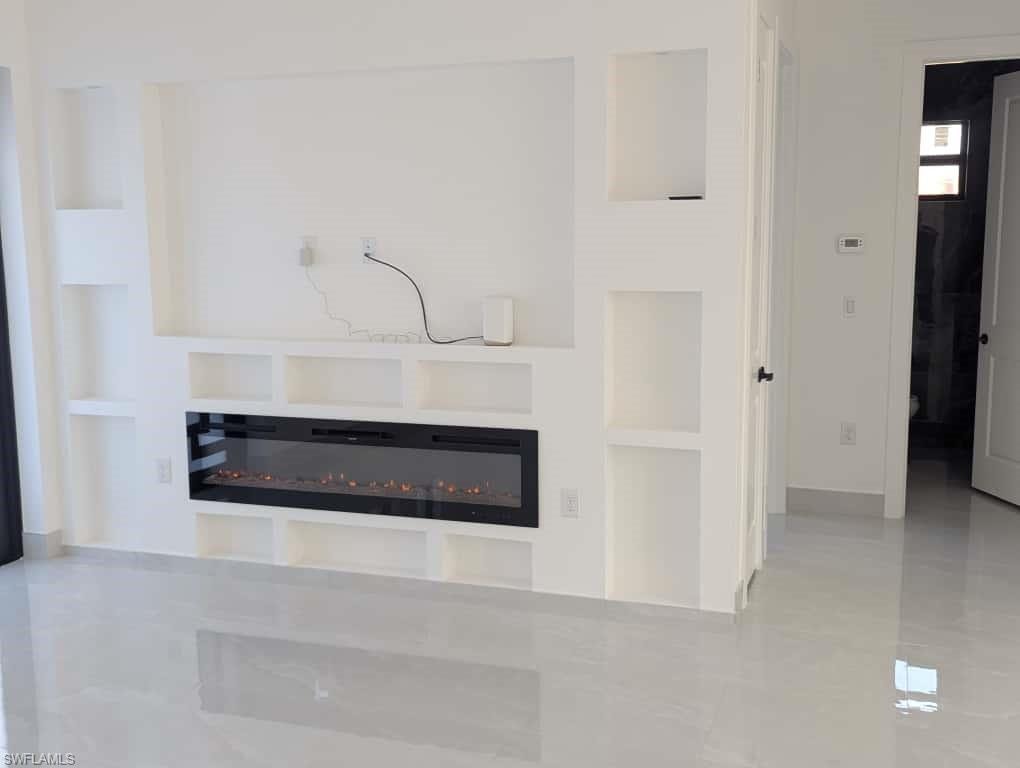 Detailed view of built in shelves and a glass covered fireplace