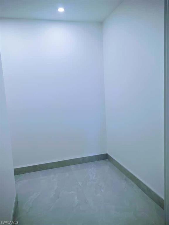 Unfurnished room featuring baseboards and concrete floors