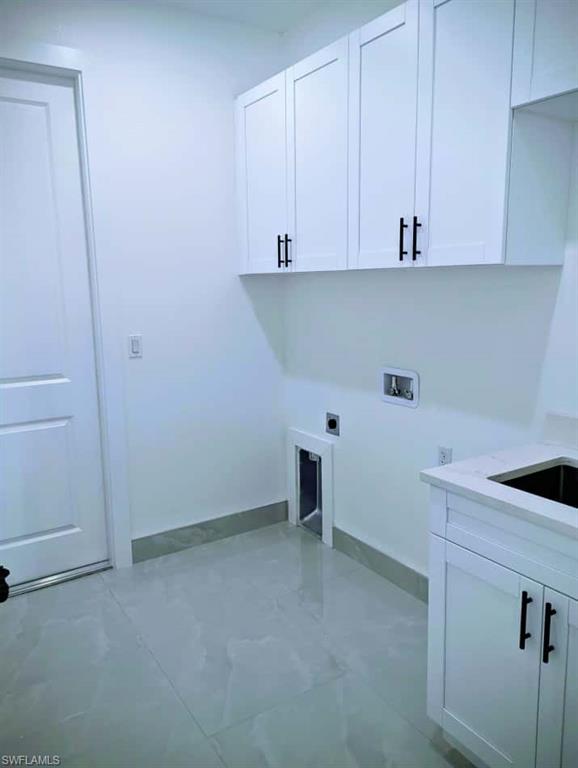 Washroom featuring cabinet space, electric dryer hookup, and washer hookup