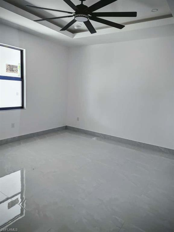 Spare room featuring concrete flooring and baseboards