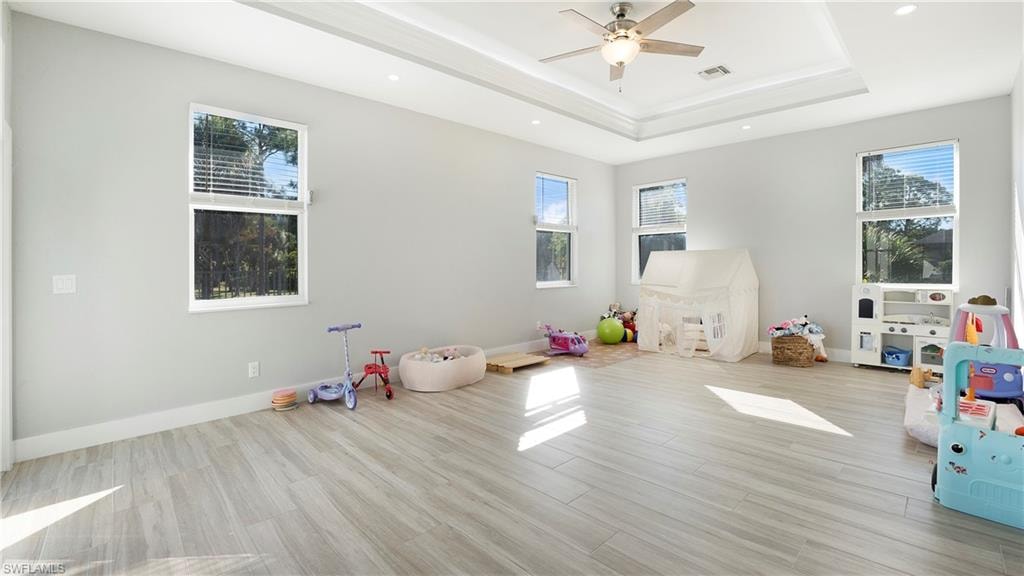 Playroom featuring wood finish floors, healthy amount of natural light, recessed lighting, and ceiling fan
