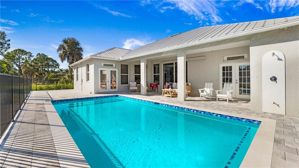 View of swimming pool with french doors and a patio