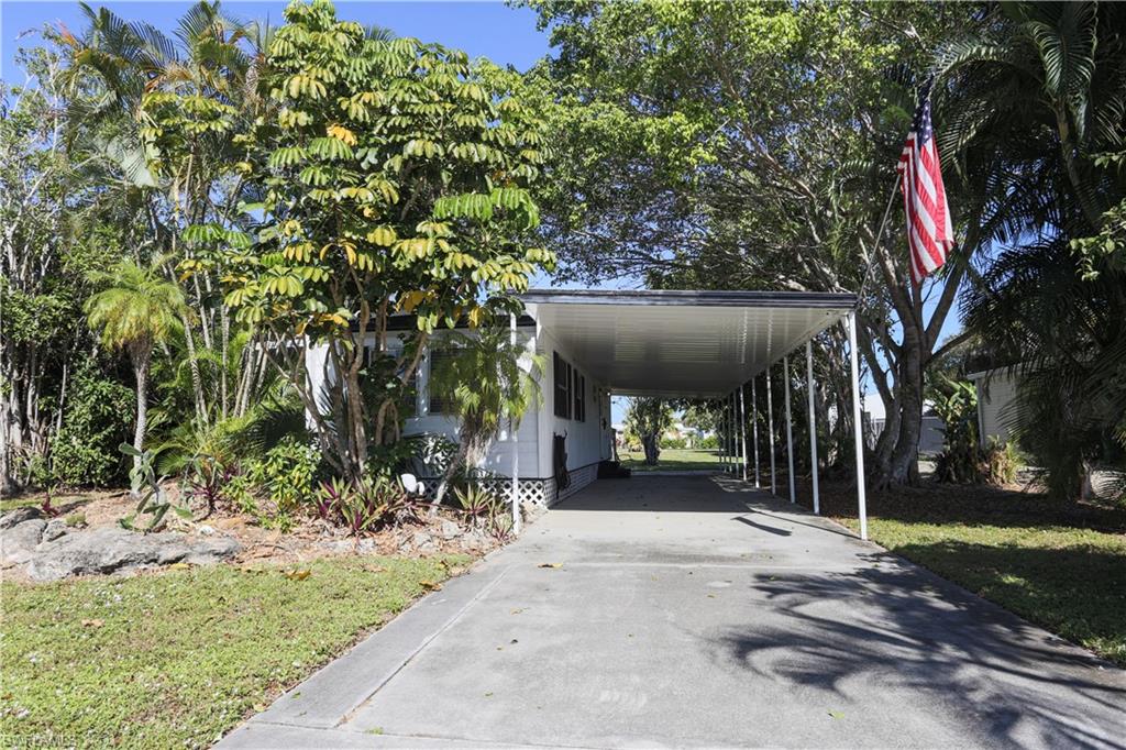 View of vehicle parking featuring driveway and a carport