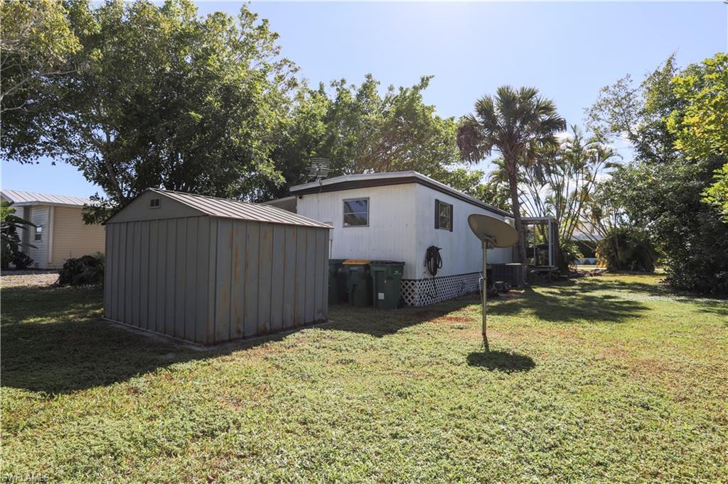 View of property exterior featuring a storage shed and a yard