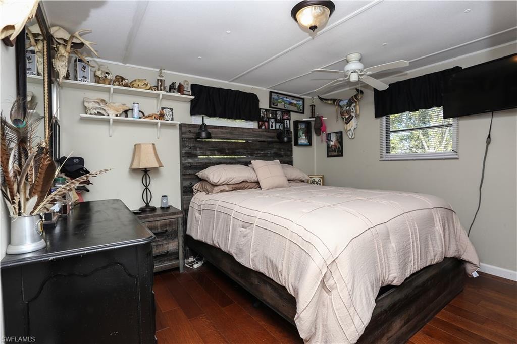 Bedroom with dark wood finished floors and a ceiling fan