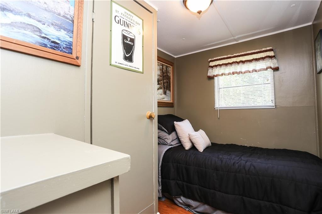 Bedroom featuring ornamental molding and wood finished floors
