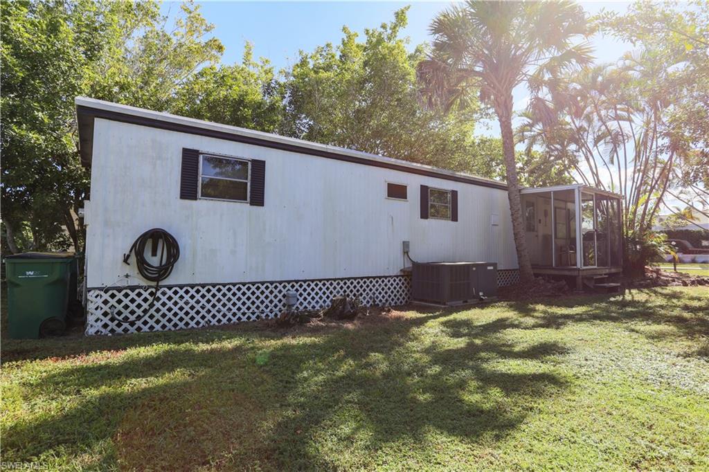 View of home's exterior with a yard and a sunroom